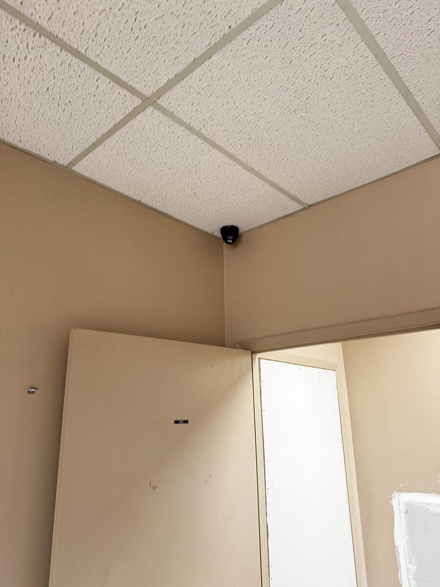 Discreet dome camera in the corner of an office ceiling